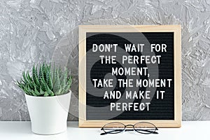 Don`t wait for the perfect moment, take the moment and make it perfect. Motivational quote on letter board, succulent flower and