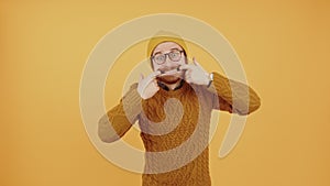 Don't worry, let's make silly faces together. Studio shot of a caucasian bearded guy in knitted sweater and a