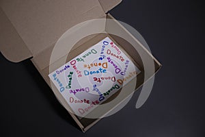 `Donate` sign handwritten with multicoloured letters in a box. donation concept. Context of The Coronavirus Pandemic