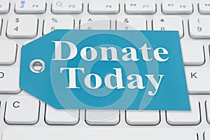 Donate Today message on a gift tag on gray keyboard