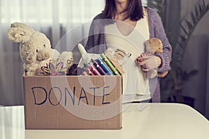 Donation box with children toys. woman collects toys for charity.