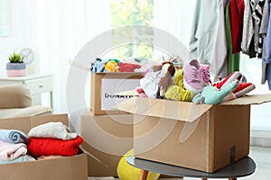 Donation box with clothes and toys on table indoors