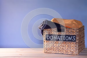Donation box for clothing donations on a blue background. Charity and donation concept. Copy space.