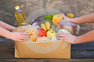 Donation box with food on old wooden background