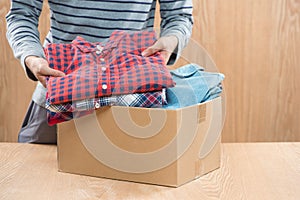 Donation box for poor with clothing in male hands