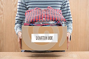 Donation box for poor with clothing in male hands