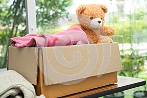 Donation box with used clothes and doll at home to support help for poor people in the world