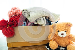 Donation box with used clothes and doll at home to support help for poor people in the world