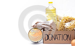 Donation box with various food items. Open a cardboard box with butter, canned goods, cereals and pasta. Copy space. Food delivery