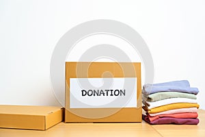 Donation, Charity, Volunteer, Giving and Delivery Concept. Clothes with Donation box at home or office for support and help poor,