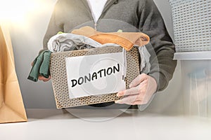 Donation concept. Donation box with donation clothes. Helping poor and needy people. box for poor with clothing in male hands.