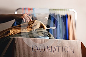 Donation Concept. Preparing Used Old Clothes from Wardrobe Rack into a Donate Box