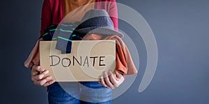 Donation Concept. Woman holding a Donate Box with full of Clothe photo