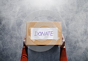 Donation Concept. Woman holding a Donate Box for Giving. Sharity activity. Top View