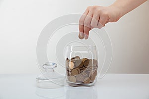 Donation concept. Woman`s hand putting coin in the money box.