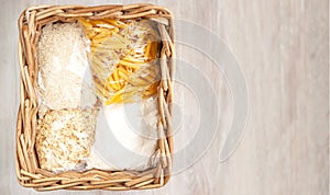 Donation food delivery help basket box cereals, rice, pasta, flour, white natural wooden background