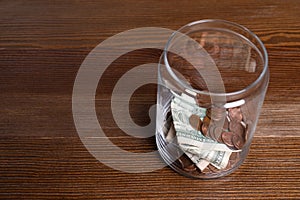 Donation jar with money on wooden background