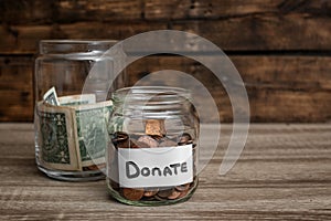 Donation jars with money on table