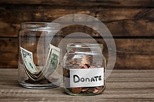 Donation jars with money on table
