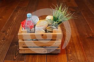 Donation volunteer box with various products for poor or elderly people on wooden background