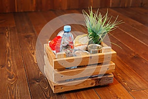 Donation volunteer box with various products for poor or elderly people on wooden background