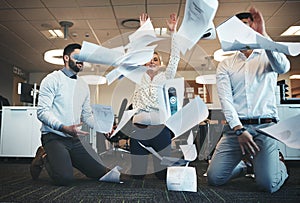 Done with all this work. businesspeople throwing paperwork in the air in the office.