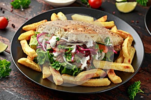Doner kebab, fried lamb meat with vegetables, fries and garlic sauce in turkish bread