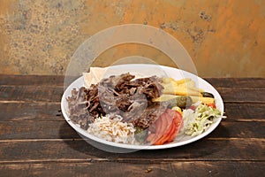 Doner kebab is lying on the cutting board. Shawarma with meat, onions, salad lies on a dark old wooden table