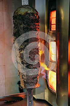 Doner kebab is lying on the cutting board. Shawarma with meat, onions, salad lies on a dark old wooden table