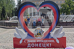 Donetsk, Ukraine - August 26, 2017: Children at the fountain and the symbolism of the self-proclaimed state in the central square