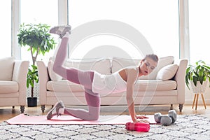 Donkey kicks exercise. Fit woman doing fitness donkey kicks exercise indoor at home