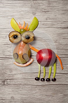 Donkey made with fruits on wooden background