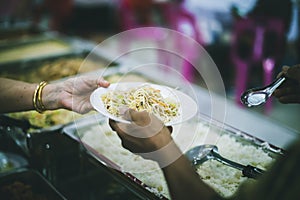 The donor gives warm food to the recipients with concern, donating food to the poor in Asian society : concept of sharing food to