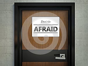 Dont be afraid sign hanging on a office door