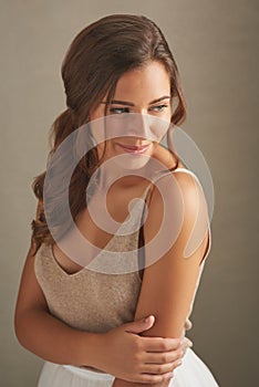 Dont be afraid to embrace your inner beauty. Studio shot of an attractive young woman posing against a brown background.