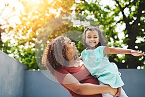 Dont be afraid to fly. a happy little girl and her mother having fun in their backyard.