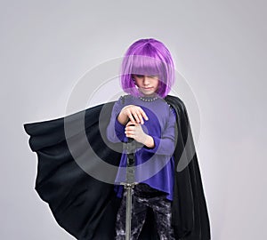 Dont be mistaken with her strength. A studio shot of a confident little girl playing dress-up.