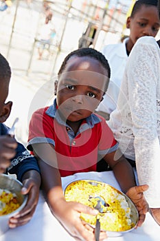 Dont even think about it...Cropped portrait of a young boy getting fed at a food outreach.
