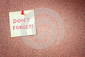 Dont forget or do not forget reminder, written on Yellow Sticker on Cork Bulletin or Message Board. photo
