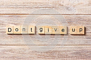 Dont give up word written on wood block. Dont give up text on table, concept photo