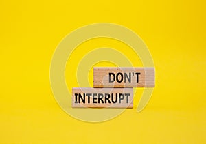 Dont interrupt symbol. Concept word Dont interrupt on wooden blocks. Beautiful yellow background. Business and Dont interrupt photo