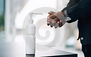 Dont let germs get the better of you. an unrecognisable man disinfecting his hands with hand sanitiser.