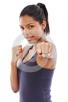 Dont mess with her. A fit young woman throwing a punch at you while isolated on a white background.