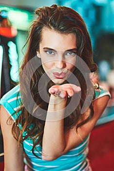 Dont miss out, shes blowing you a kiss. a beautiful young woman in a diner.