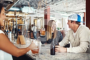 They dont need an excuse to celebrate. a couple enjoying a drink at a bar.