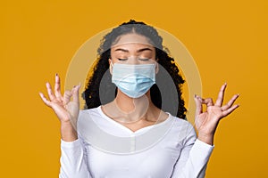 Dont Panic. Young black woman wearing medical mask meditating with closed eyes