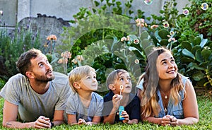 Dont pay your company with hours stolen from your family. Portrait of a beautiful family laying on the grass and playing