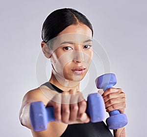 Dont stop at the slightest bit of sweat. an attractive young woman standing and posing with dumbbells during her workout