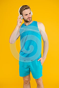 Dont stop training. Athletic man listen to music yellow background. Athletic training. Physical training activity