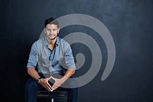 Dont stop until victory is yours. Studio portrait of a confident young businessman posing against a dark background.